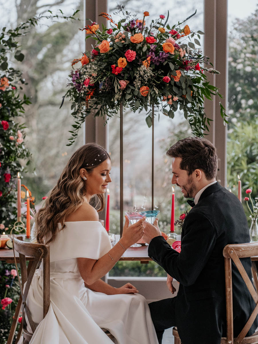 Bride and groom at a wedding table at Trevenna in Cornwall surrounded by beautiful floral designs created by Artem Florum