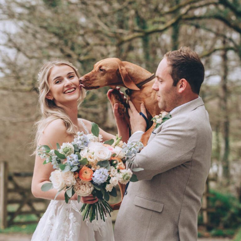 A gorgeous bride and handsome groom with an adoring dog and a bouquet created by Artem Florum