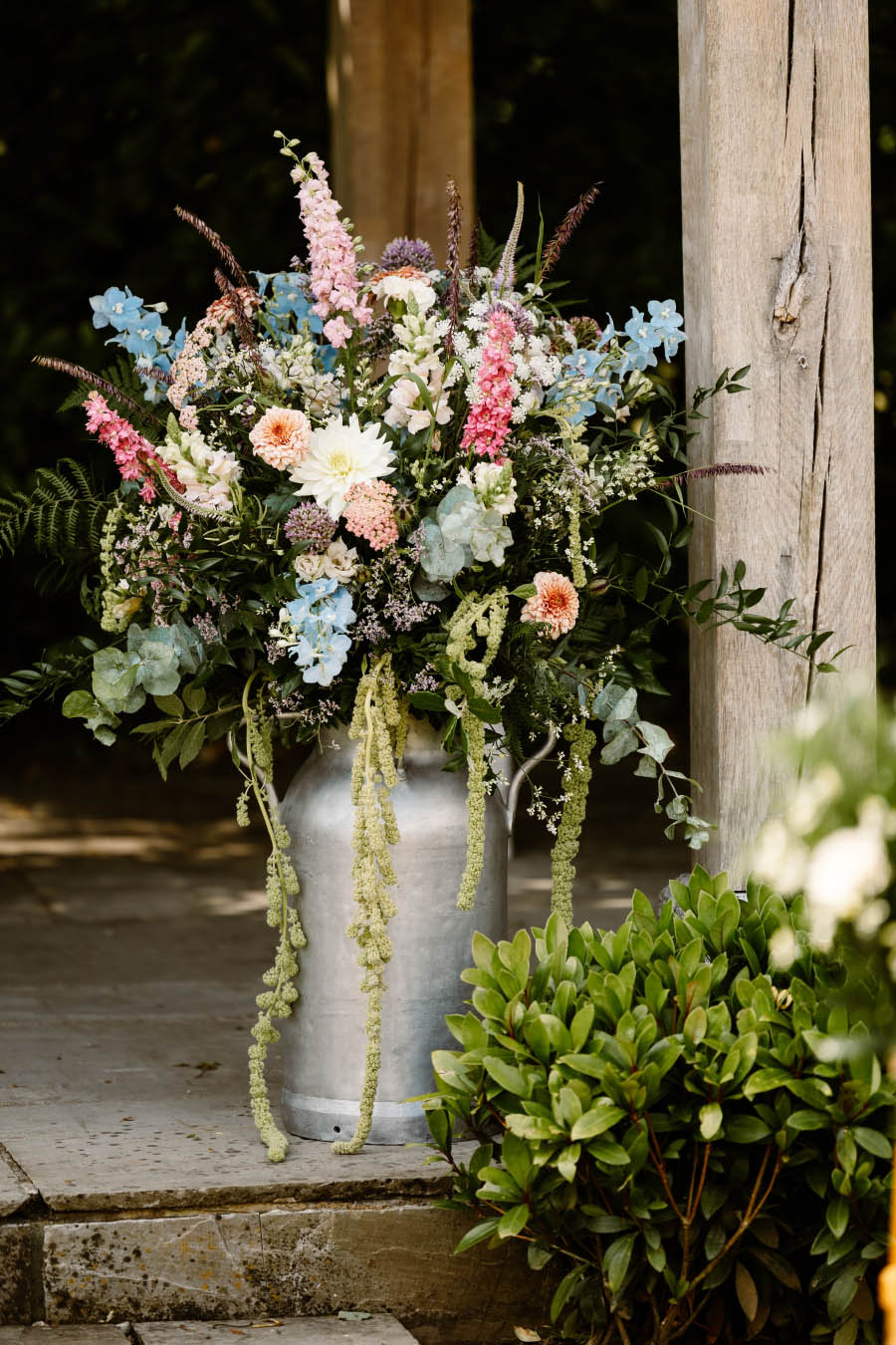 A milk churn filled with a beautiful pastel floral design, created by Artem Florum.