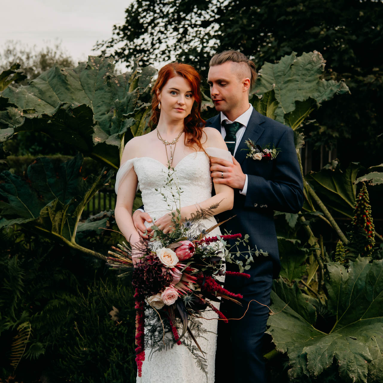 A beautiful bride and handsome groom embrace in a gothic-inspired wedding with floral design by wedding florist Artem Florum.