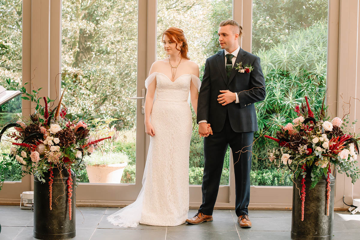 The bride and groom at a Gothic-inspired wedding in Cornwall, with stunning floral arrangements by Artem Florum.