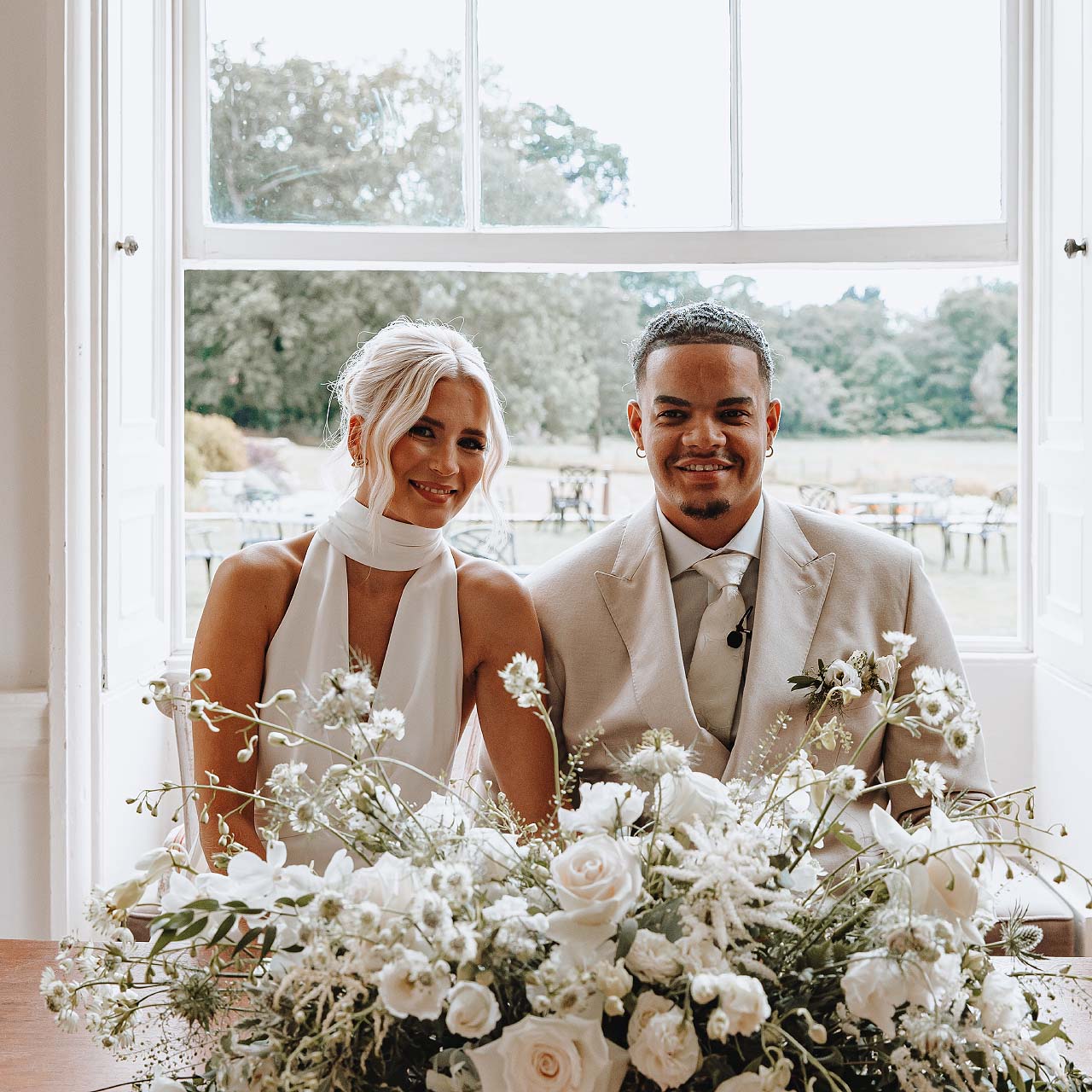 A bride and groom at Rockbeare Manor with a floral table display by Artem Florum.
