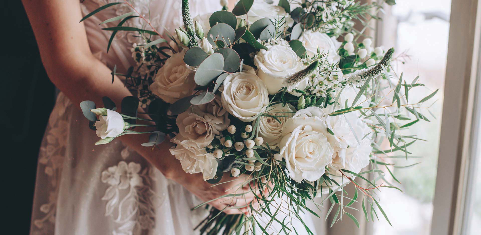 Elegant white bridal bouquet of roses designed by Artem Florum for a wedding in Devon.